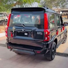 the rear end of a black suv parked in a parking lot