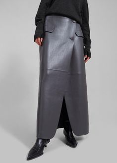 Color: Grey Midweight faux leather fabric Regular fit Maxi length Asymmetrical hem Asymmetrical front slit Illusion front flap pockets Front button closure Lined 100% Polyurethane Dry Clean By The Frankie Shop. Imported Cross Skirt, Causal Chic, Skirt Streetwear, Pu Leather Skirt, Leather Apron, The Frankie Shop, 2024 Color, Frankie Shop, Creative Stuff