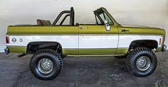 a green and white truck parked in a garage