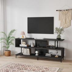 a living room with a large flat screen tv mounted on the wall above it's entertainment center