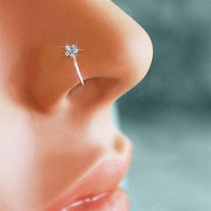 a woman's nose with a single diamond piercing on it, and the tip of her nose is visible