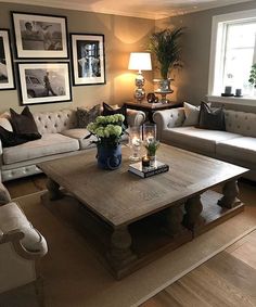 a living room with couches, tables and pictures on the wall in it's corner