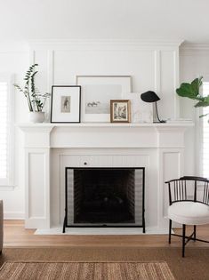 a white fireplace with pictures on the mantle