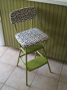 a green chair with a black and white patterned seat cover on it's back