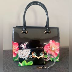 This Gorgeous Black Floral Bag Is Brand New! Large Floral Detailing In Bright And Beautiful Shades On The Bag As Well As The Small Coin Bag Are Eye Catching. This Purse Is Not For Those That Don’t Want To Be Noticed. It’s A Purse For Those That Like Being Seen Because Of Their Immaculate Taste In Purses. This Purse Can Also Be Used As A Crossbody. This Beauty Comes With: Details: * Zippered Center Compartment * Zippered Inside Side Pocket * 2 Inside Side Pockets * Zippered Small Credit Card/Coin Black Rectangular Satchel For Spring, Elegant Black Bags With Floral Print, Elegant Top Handle Bag With Floral Print, Black Floral Print Tote Bag, Rectangular Floral Print Shoulder Bag For Evening, Black Rectangular Shoulder Bag With Floral Print, Black Floral Print Shoulder Bag For Everyday Use, Elegant Black Floral Print Shoulder Bag For Everyday Use, Elegant Floral Print Tote Bag