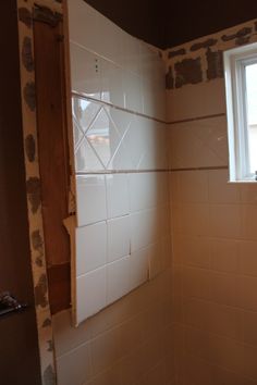 a bathroom that is being remodeled with white tiles on the walls and in the shower