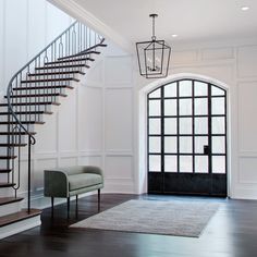 an elegant entryway with stairs and bench next to the entrance door that leads up to the second floor