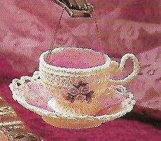 a painting of a tea cup and saucer on a pink tablecloth with gold trimmings