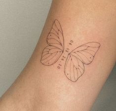 a small butterfly tattoo on the arm with words written in it's wing shapes