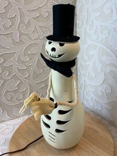 a white snowman with a black top hat and scarf