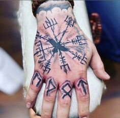 a person's hand with tattoos on it and other symbols painted on the palm