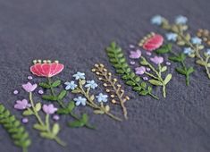 embroidered flowers and leaves on a gray surface