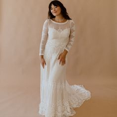 a woman in a white wedding dress posing for the camera with her hands on her hips