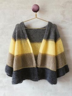 a gray and yellow striped sweater hanging on a wall