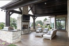 a covered patio with furniture and an outdoor fireplace