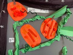 an orange paper plate with carrots cut out of it and some other items on the table