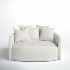 a white couch with four pillows on it's back and two sides facing each other