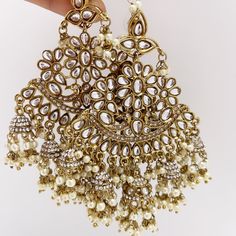 Oversized dull gold Antique finish Bollywood Kundan Earring with sahare /Indian/Punjabi/Pakistani/Statement/Long chandelier/bridal/wedding Length: 4 Inches; Width: 2.5 Inches Arrives in a gift box Color, shades, texture displayed may slightly vary from the actual product due to digital image limitations. We request you to consider these minor variations. Please expect the possibility of some slight imperfections when buying handmade jewelry. If you have any questions, please contact us. Luxury Bollywood Chandbalis For Festive Occasions, Chandbalis Earrings, Long Chandelier, Kundan Earrings, Buy Handmade, Box Color, Antique Finish, Color Shades, Bridal Wedding