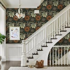 a white staircase with floral wallpaper in a house