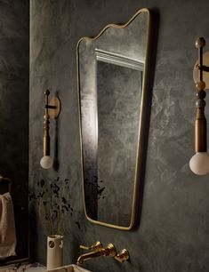 a bathroom sink sitting under a mirror next to a faucet mounted on a wall