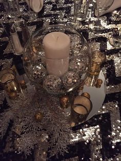 a table topped with lots of silver sequins and candles