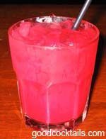 a red drink in a tall glass with a silver straw sticking out of the top