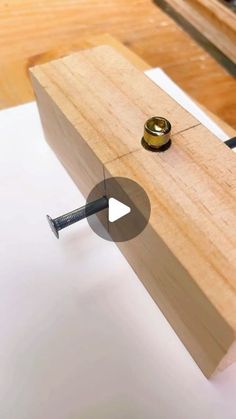 a piece of wood is being worked on with a screw and nut in the middle