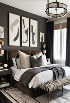 a bedroom with black walls and white bedding, two pictures on the wall above the bed