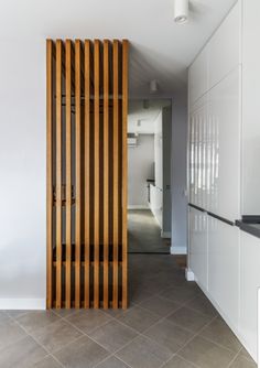 an empty kitchen with wooden slats on the wall and tile flooring in front of it