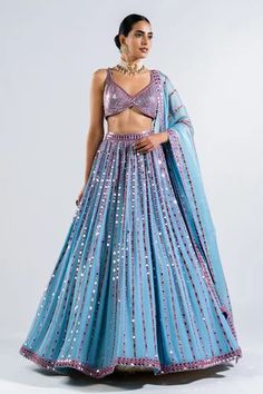 Ice blue lehenga with mirror embroidery in a stripe pattern and multicolor thread work. Comes with sequin embroidered blouse and border embroidered dupatta.
Components: 3
Pattern: Embroidery
Type Of Work: Mirror and Sequin
Neckline: V neck
Sleeve Type: Sleeveless
Fabric: Lehenga and Blouse- Georgette and Dupatta: Satin Organza
Color: Blue
Other Details: 
Low back with tie up and tassels
Dupatta with mirror embroidered border
Closure: Back hook
Note: Choker worn by the model is not for sale
Occas Tassels Dupatta, Vani Vats, Lehenga Dupatta, Punjabi Fashion, Mirror Embroidery, Bridal Lehenga Collection, Georgette Dupatta, Metallic Blouses, Blue Lehenga