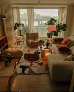 a living room filled with lots of furniture next to a large window covered in curtains