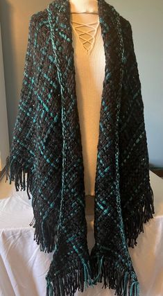 a black and teal knitted shawl on a mannequin