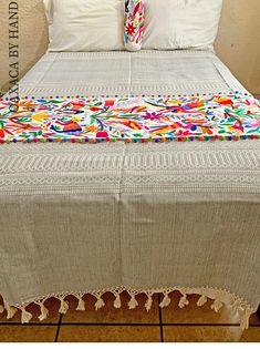 a bed with white linens and colorful pillows