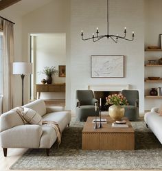 a living room with two couches and a coffee table in front of a fireplace