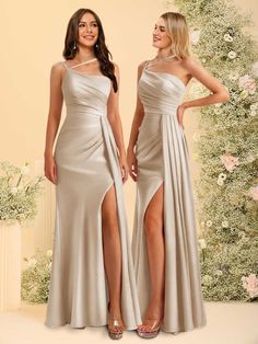 two women standing next to each other wearing dresses with thigh high slits on the sides