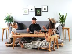 a man and two children sitting on a couch with a table in front of them