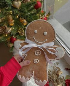 a person holding up a ginger shaped cookie