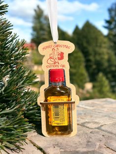 an ornament hanging from a pine tree with a bottle of essential oil in it