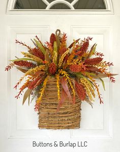 a basket filled with lots of different types of flowers on top of a white door