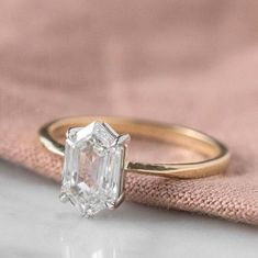 a close up of a ring with a diamond in it on a pink velvet bag