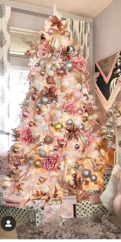 a white christmas tree decorated with pink and gold ornaments