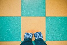 a person standing on a checkered floor with their feet in the air and wearing slippers