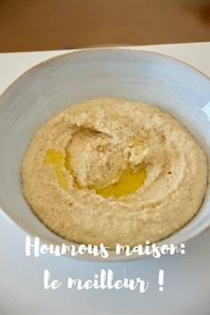 a white bowl filled with hummus on top of a table