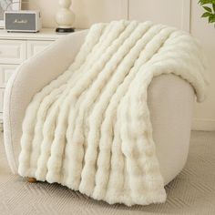 a white chair with a blanket on top of it