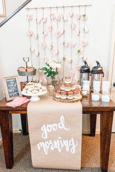 a table topped with lots of food and desserts next to a stair case filled with flowers