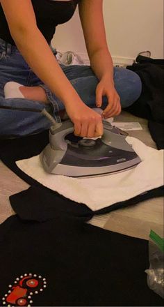 a woman ironing clothes on the floor