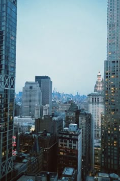 the city skyline is lit up at night, with skyscrapers in the foreground