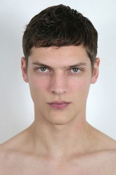 a young man with no shirt on posing for a photo in front of a white background