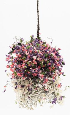 an arrangement of flowers hanging from a ceiling