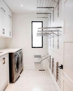 a washer and dryer in a white laundry room with stainless steel shelving